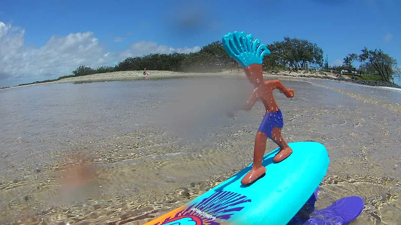 サーファーがボードに乗りサーフィンする玩具とビーチ @kosodatebrisbane.com